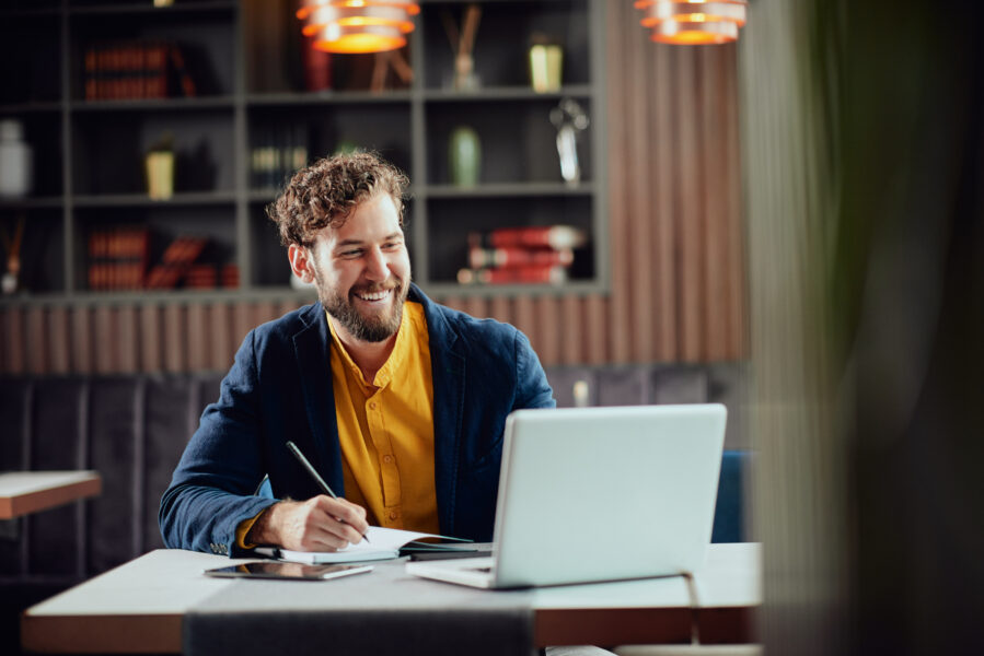 young man writing on computer. Feature photo for how to sell pdfs online blog