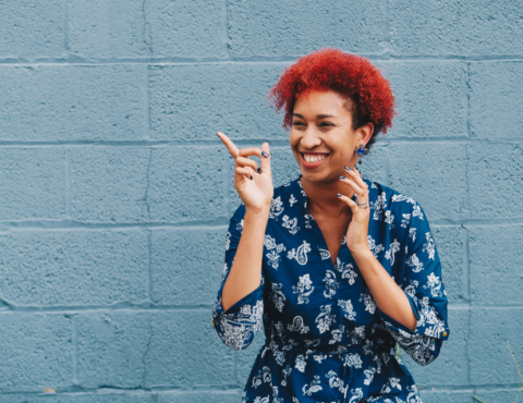 woman smiling in front of blue wall